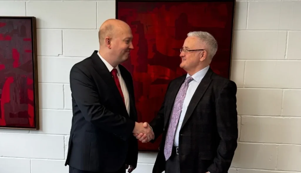 Leaders from Cherry & White and TimeBeat shake hands to mark their partnership